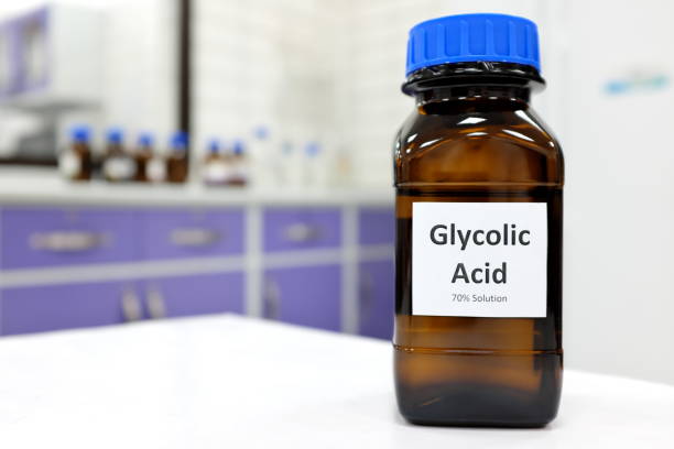 <strong>7 Awesome Ways To Use Glycolic Acid From Head To Toe!</strong> selective focus of glycolic acid liquid solution in dark brown glass bottle in a white