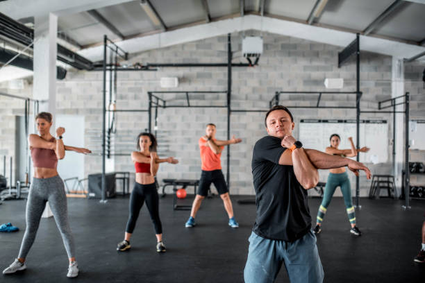 istock Multi Ethnic Group Of People Stretching Before Cross Training In The Gym 1285236982