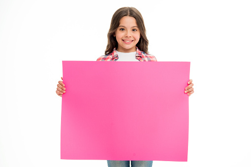 Happy girl hold pink board isolated on white. Child with adorable smile. Smiling beauty. Advertising your product.