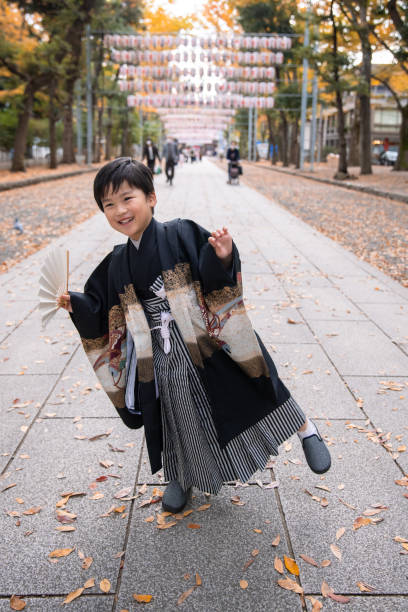 szczęśliwy mały chłopiec w "hakama" tradycyjny japoński strój taniec na ulicy dla shichi go san przypadku - ginkgo tree ginkgo tree japan zdjęcia i obrazy z banku zdjęć
