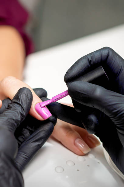 istock Manicure master applying pink nail polish 1285243565