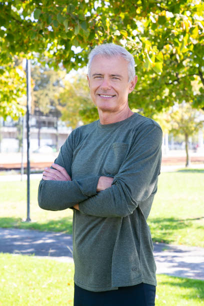 istock Positive mature man with crossed arms standing outside 1285246295
