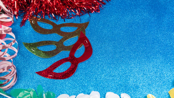 istock Brazilian carnival masks and props arranged on a shiny blue surface, top view. 1285247646