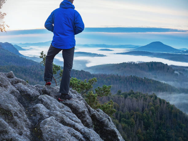 istock Nature adventure. Hiker on the rock with hands in pocket 1285248868