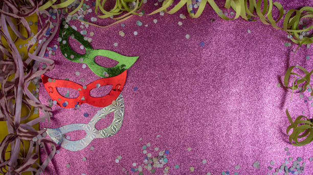 istock Brazilian carnival masks and props arranged on a shiny pink surface, top view. 1285248987