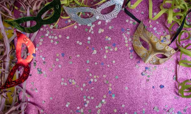 istock Brazilian carnival masks and props arranged on a shiny pink surface, top view. 1285248989