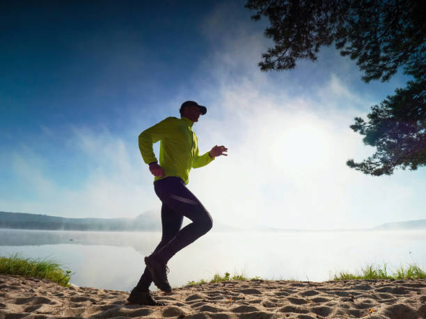istock Slim man jogging on the beach early morning. 1285249447