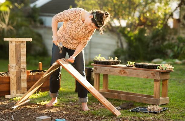 istock Young woman making a planting box outside in her backyard 1285250471