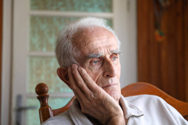 istock Old man sitting on rocking chair 1285254212