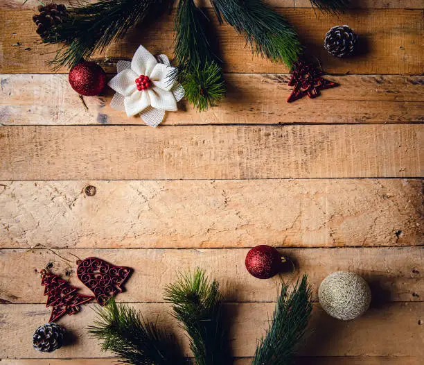 Christmas wooden background with gift boxes, Christmas balls, branches, tree, and decorations