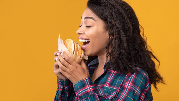 istock Funny African American Lady Eating Burger At Studio 1285255438
