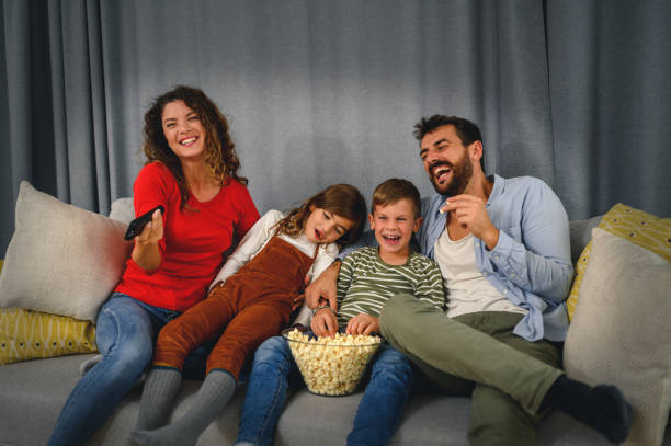 istock Family eating popcorn while watching tv at home 1285255473