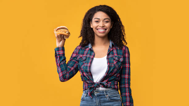 istock Funny African American Lady Showing Burger At Studio 1285255583