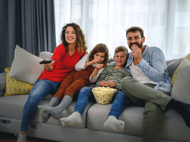 istock Family eating popcorn while watching tv at home 1285256871