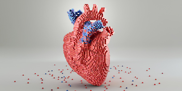 A conceptual image of a 3D model of a heart made from small multi-toned red and blue blocks. The model rests on a plain white surface, surrounded by blocks scattered at its base. A plain background with copy space.
