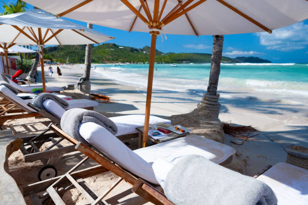 Chairs and umbrellas on Nikki Beach, St. Barthelemy Chairs and umbrellas on Nikki Beach, St. Barthelemy st jean saint barthelemy stock pictures, royalty-free photos & images