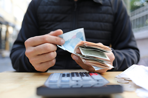 hombre haciendo transacciones financieras con calculadora que tiene dinero photo