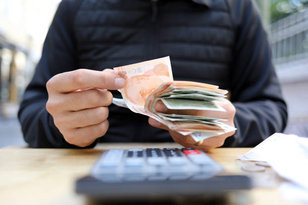 istock man doing financial transactions with calculator holding money 1285258444