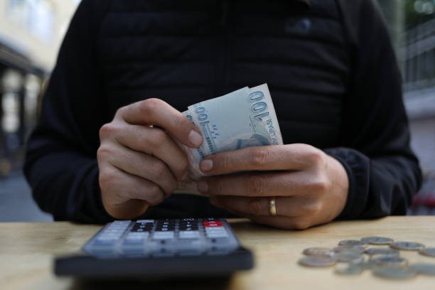 istock man doing financial transactions with calculator holding money 1285259111