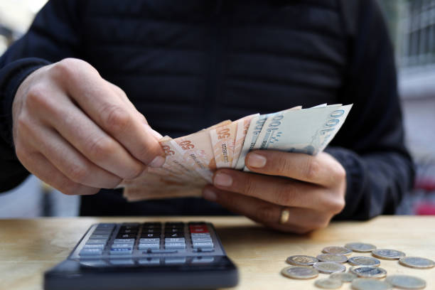 istock man doing financial transactions with calculator holding money 1285259841