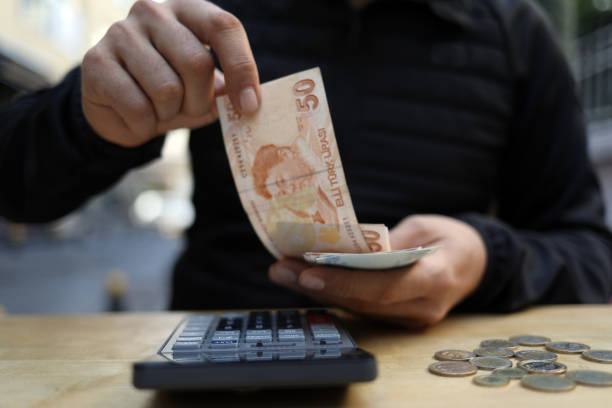 istock man doing financial transactions with calculator holding money 1285260528