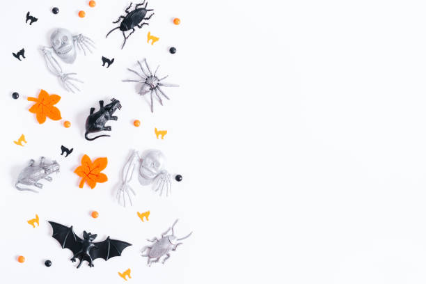 istock Halloween border on white with orange, black and silver holiday decor. Silver bats and ghosts flying around, copy space, gothic holiday flat lay 1285260762