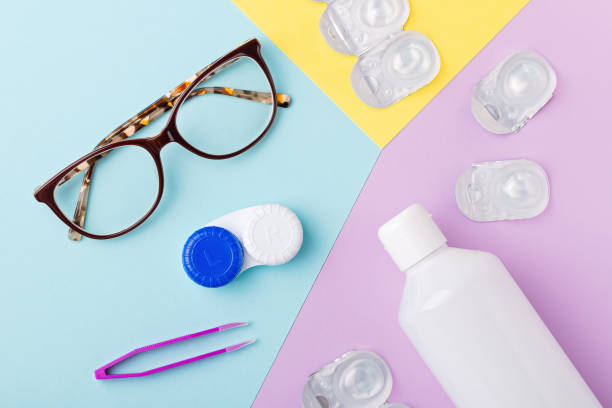 istock Contact lens kit with bottle of lens solution, case, tweezer on multicolor background, flat lay, top view 1285262269