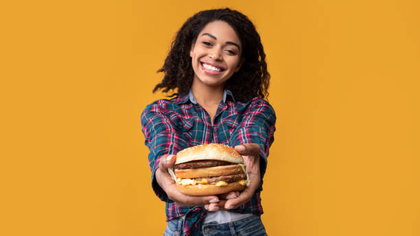 Funny African American Lady Giving Burger At Studio