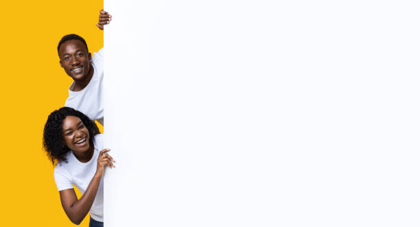 istock Smiling black man and woman standing next to blank placard 1285262807