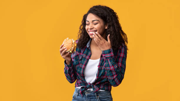 istock Happy African American Lady Eating Burger At Studio 1285263407