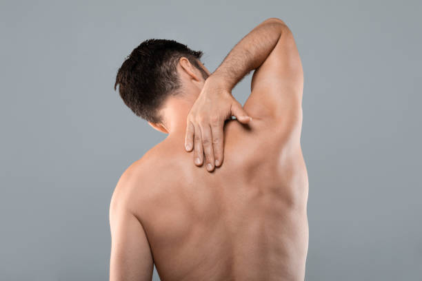 hombre irreconocible frotándose la espalda en la zona del cuello, con calambres - acute mountain sickness fotografías e imágenes de stock