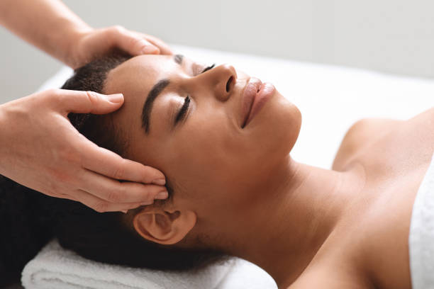istock Unrecognizable masseuse massaging relaxed black lady head 1285263941