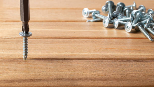 istock The screwdriver twists the self-cut into wooden boards. Construction tools, home repairs. 1285264455
