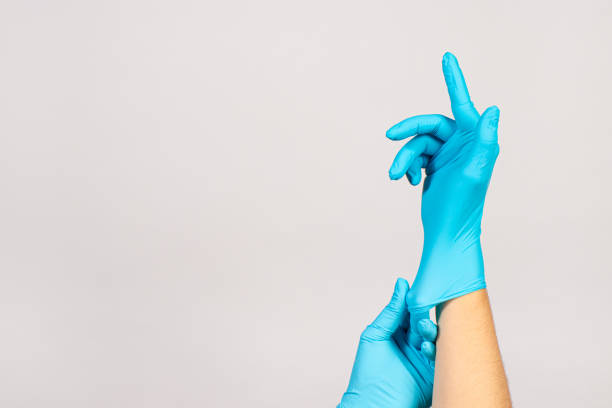 istock The surgeon wears blue gloves before the operation on a white background with a place for copyspace text. Banner for Surgery, Proctology and Medicine 1285264478