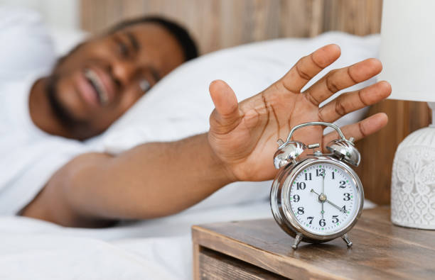 istock African Guy Turning Off Alarm Clock Waking Up At Home 1285266961