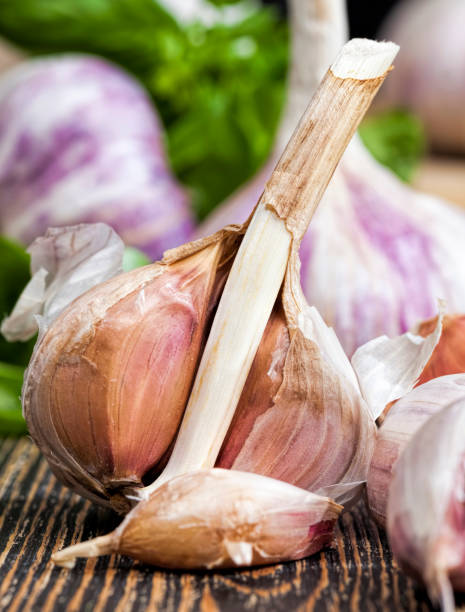 broken garlic and green Basil vegetables on the table during cooking ripe broken garlic and green Basil vegetables and spices on the cutting Board close up Relish stock pictures, royalty-free photos & images