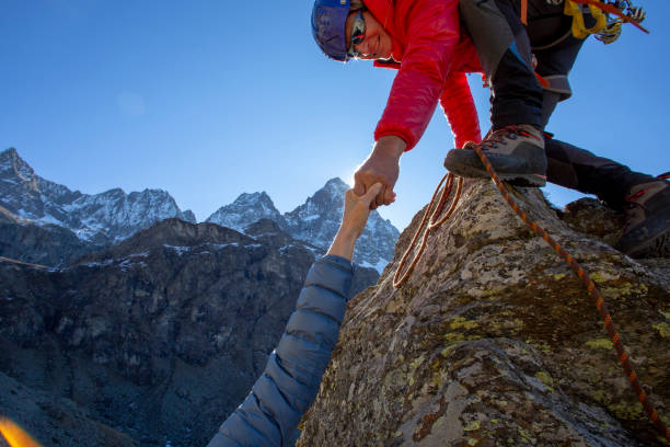 등산가가 동반자에게 도움의 손길을 제공합니다. - rock climbing climbing mountain climbing leading 뉴스 사진 이미지