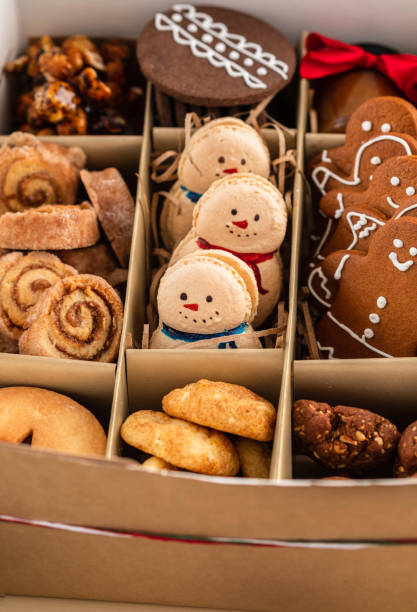 Tasty homemade Christmas cookies in a craft box. closeup view A variety of Christmas cookies on wooden board - linzer alfajores gingerbread spritz butter cookies Russian tea cookies tea candles and festive decoration. 1528 stock pictures, royalty-free photos & images