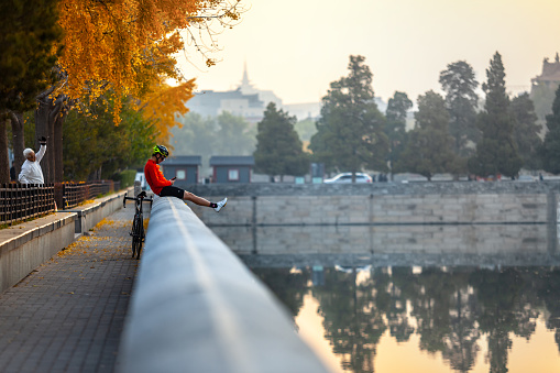 Beijing, China - November 12, 2019: Bicyclist having rest after morning sports exercises at Forbidden City moat