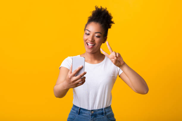 istock Happy black lady taking selfie using mobile phone 1285269145