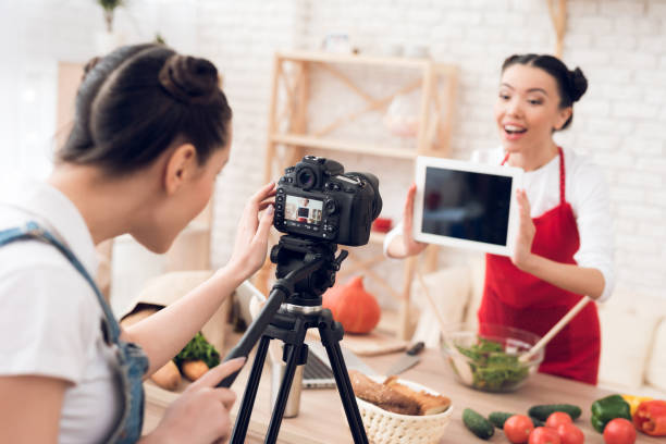 istock Culinary blogger girl holds up blank tablet to camera. 1285269211