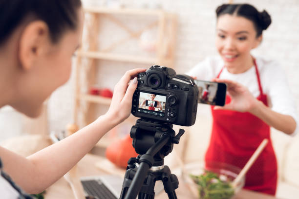 istock Two culinary bloggers taking selfie with one girl behind camera. 1285269244
