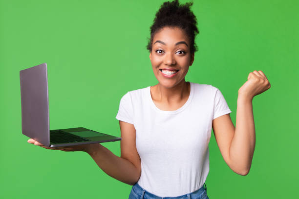 istock Excited afro lady feeling ecstatic holding laptop 1285269330