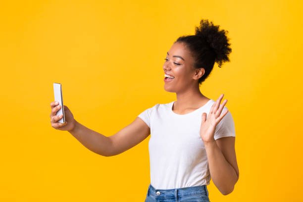 Happy black woman making video call using mobile phone