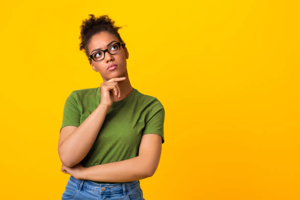 Black woman in glasses thinking about question, touching chin