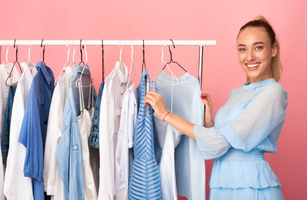 istock Young lady choosing clothes standing near rack 1285270901