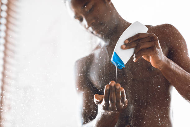 현대 욕실에서 샤워 젤 세척 몸을 붓는 흑인 남자 - men naked shower bathroom 뉴스 사진 이미지