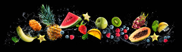 assortiment de fruits frais et éclaboussures d’eau sur fond panoramique - watermelon melon fruit juice photos et images de collection