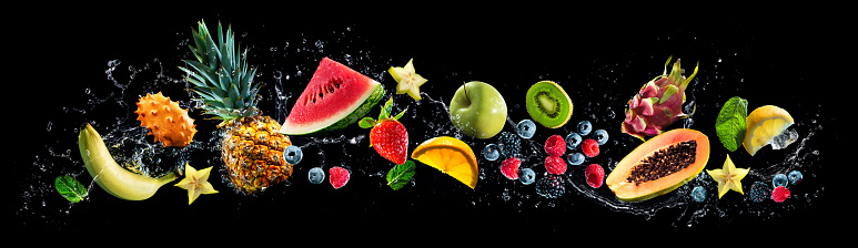 Panoramic wide black background with assortment of fresh fruits and water splashes. High resolution collage for skinali