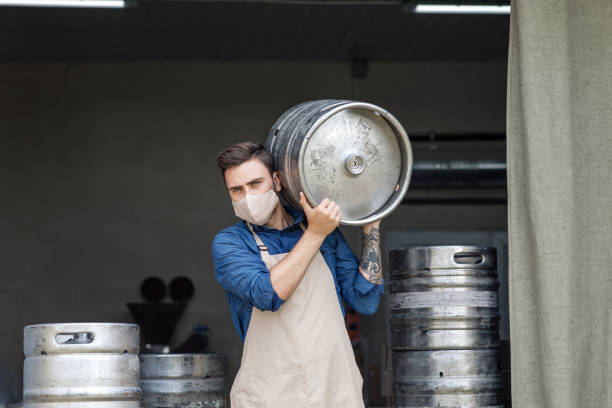 istock Young man working at warehouse in brewery or employee with keg 1285272149